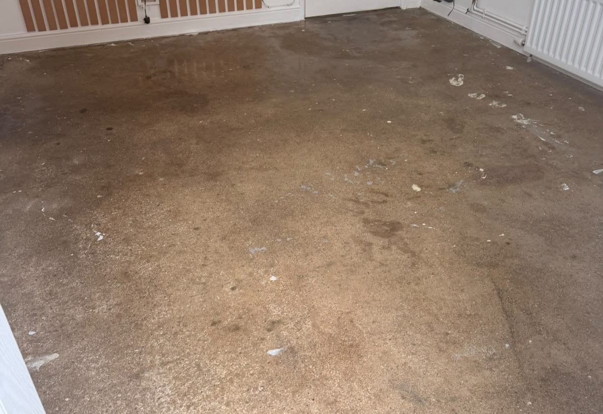 Living room before resin flooring, bare dusty concrete